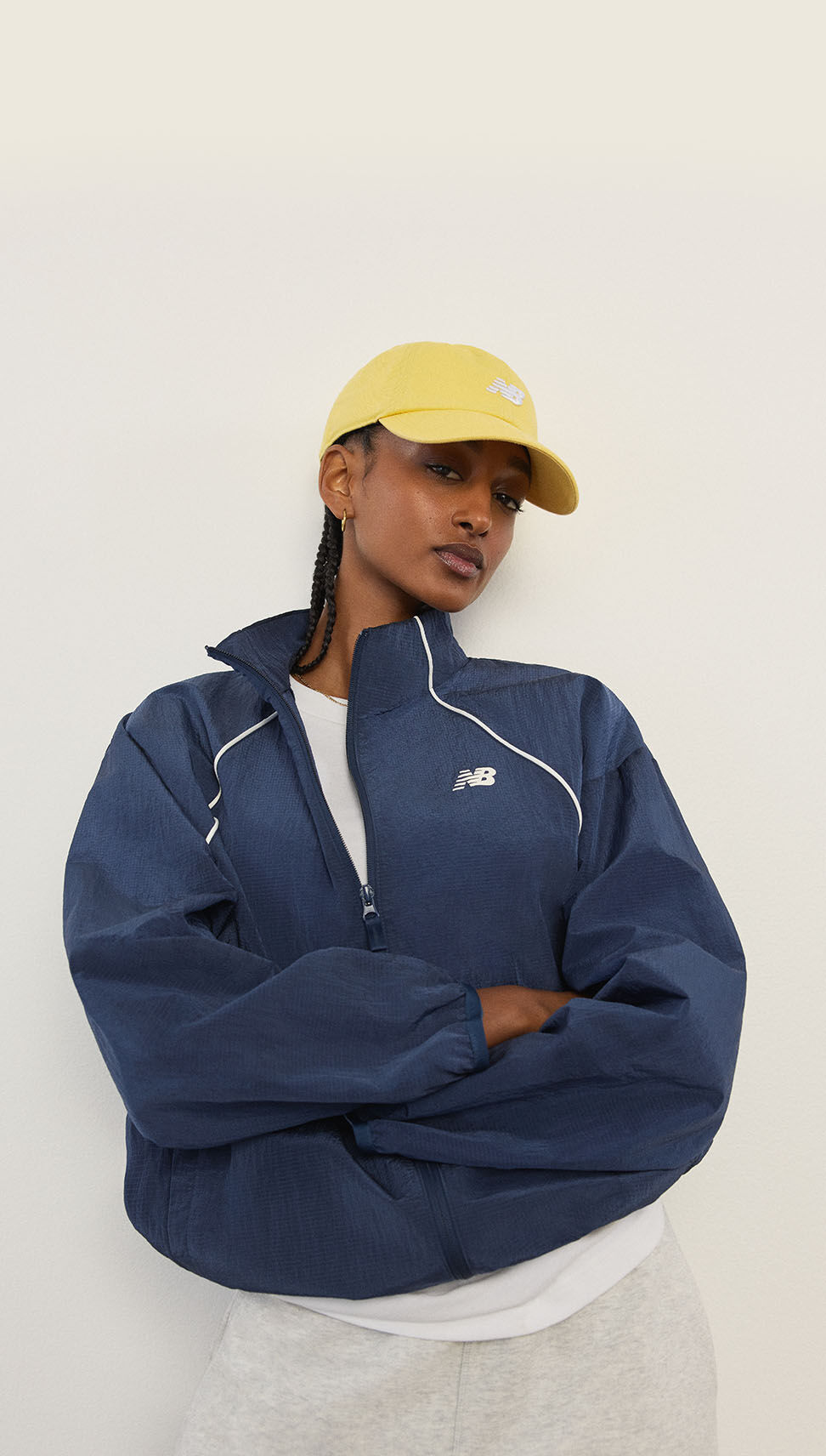 A woman standing in front of a white wall.