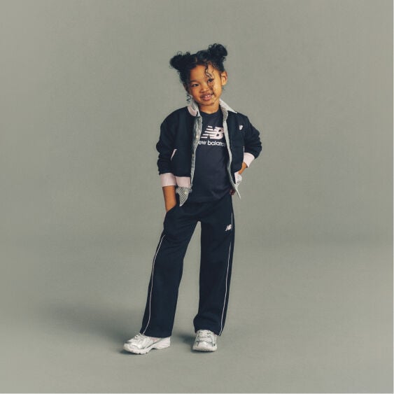 Child wearing New Balance clothes and shoes in a studio