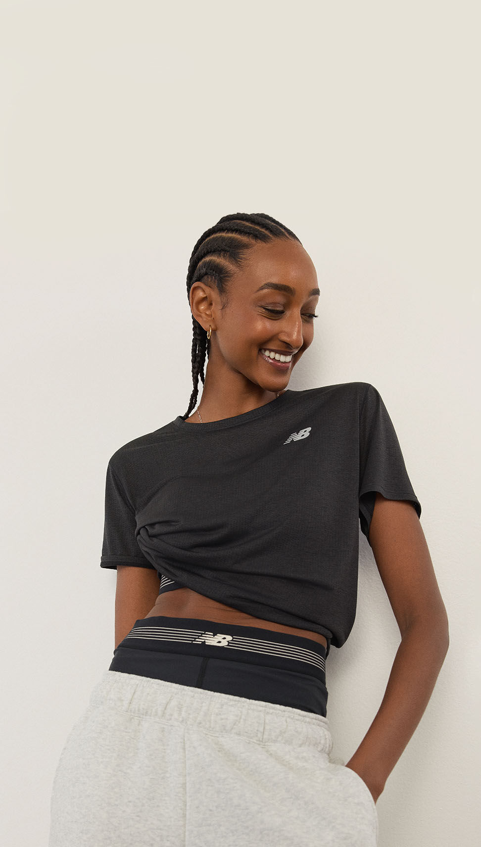 A woman standing in front of a white wall.